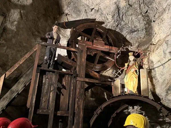Diorama mit historischer Bergmann-Figur und hölzernem Wasserrad im Schaubergwerk