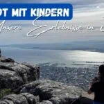 Beitragsbild mit dem Titel "Kapstadt mit Kindern - unsere Erlebnisse in 3 Tagen" mit einem Kind, das vom Tafelberg auf Kapstadt schaut
