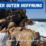 Beitragsbild mit dem Titel "Kap der guten Hoffnung - Unser Tagesausflug mit Kind" mit 2 Personen im Hintergrund, die sich fotografieren vor dem Kap und links im Eck das berühmte Schild