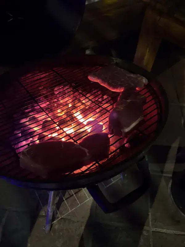 Steaks auf dem glühenden Braai-Grill am Abend