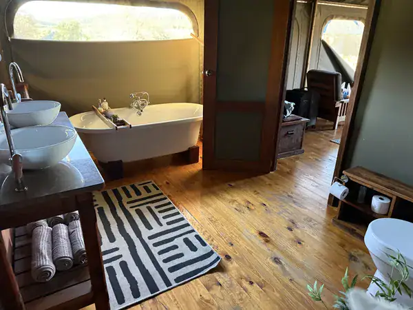 Bad im Familienzelt der Buffelsdrift Game Lodge mit freistehender Badewanne, zwei Waschbecken und Blick in die Landschaft