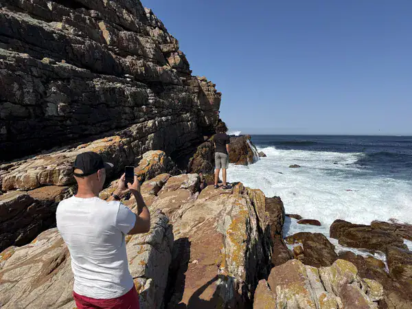 Vater und Sohn fotografieren die Brandung auf dem Klippenweg am Cape Point